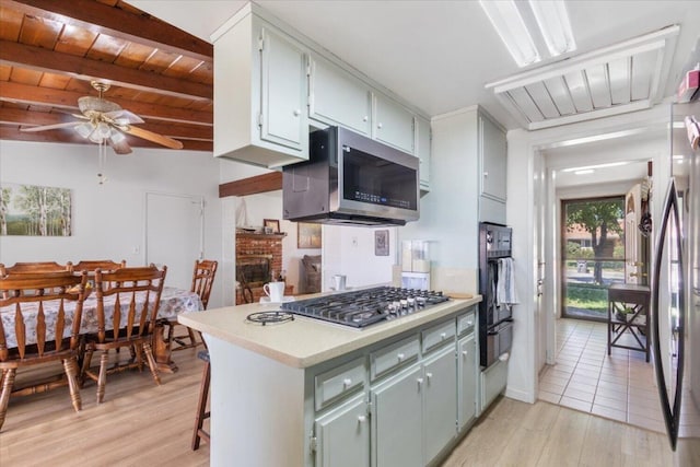 kitchen featuring wood ceiling, light wood-type flooring, kitchen peninsula, stainless steel appliances, and beam ceiling