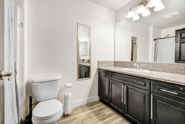 bathroom featuring wood-type flooring, vanity, and toilet