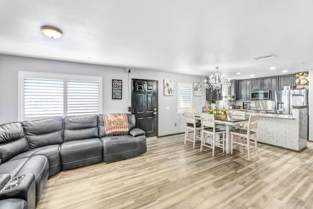 living room featuring light hardwood / wood-style floors and an inviting chandelier