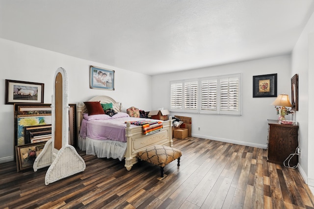 bedroom with arched walkways, baseboards, and wood finished floors