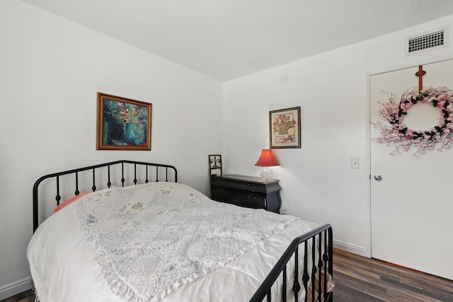bedroom featuring visible vents, baseboards, and wood finished floors
