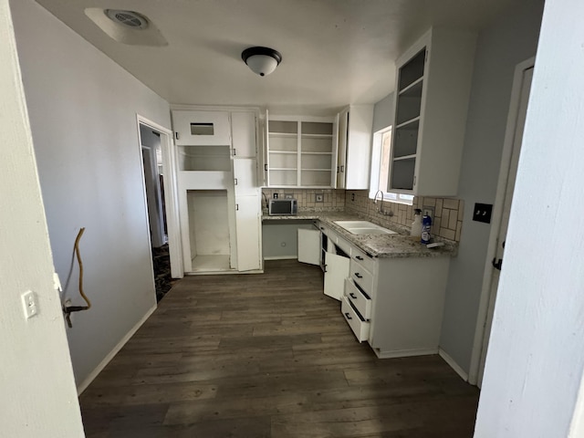 kitchen with decorative backsplash, light stone counters, sink, white cabinets, and dark hardwood / wood-style floors