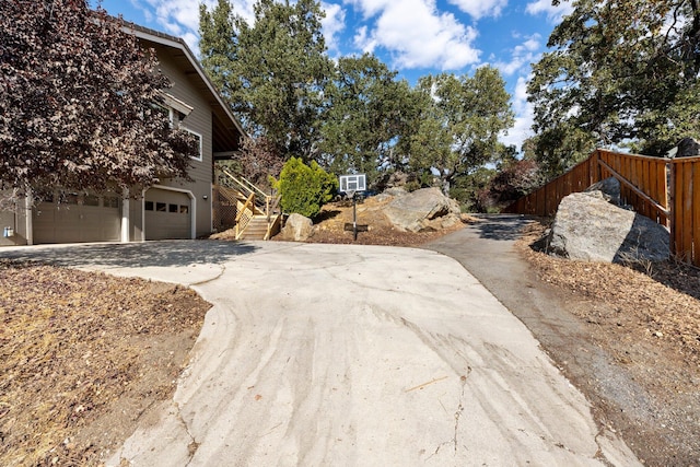 24500 Deertrail Dr, Tehachapi, CA 93561 - view of property exterior featuring concrete driveway, an attached garage, fence, and stairs