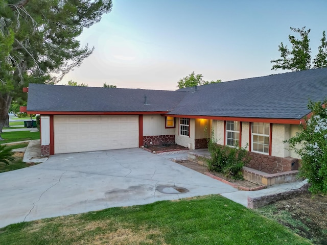 single story home with an attached garage, concrete driveway, and roof with shingles