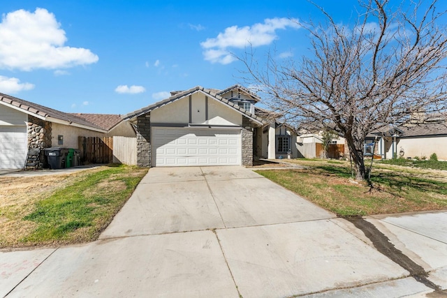 view of front of house with driveway, stone siding, an attached garage, and fence