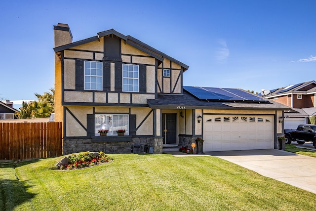 english style home with a garage, fence, driveway, stucco siding, and a chimney