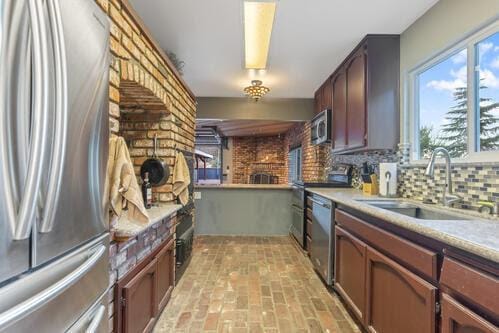 kitchen with appliances with stainless steel finishes, sink, and backsplash