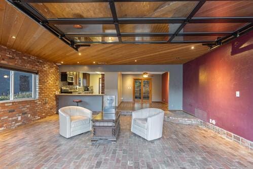 living room with wooden ceiling and brick wall