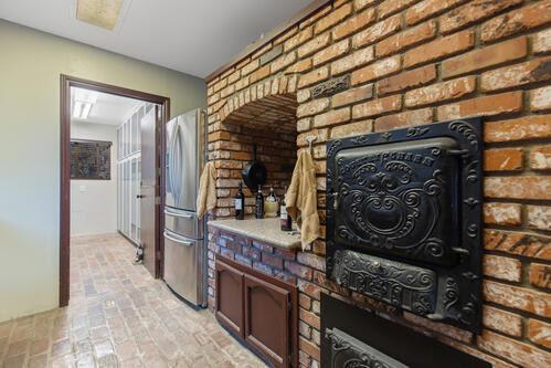 interior space featuring brick wall, stainless steel fridge, and a fireplace