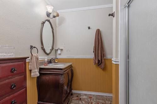 bathroom with vanity, wooden walls, and a shower with shower door