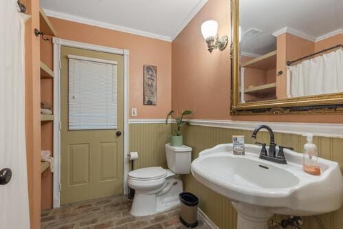 bathroom featuring sink, crown molding, and toilet