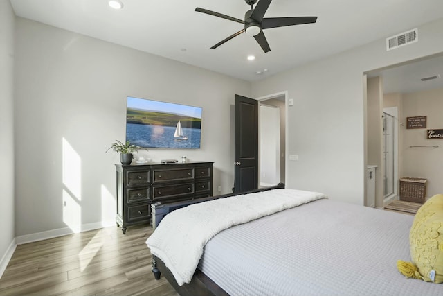 bedroom featuring connected bathroom, wood-type flooring, and ceiling fan