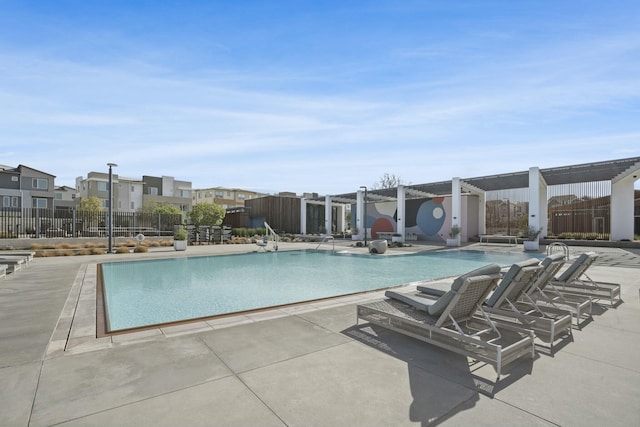 view of swimming pool featuring a hot tub and a patio area