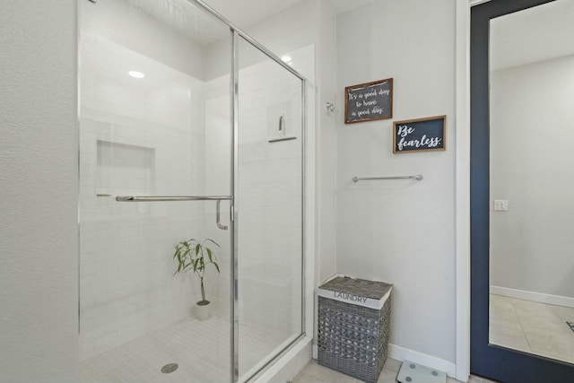 bathroom with tile patterned flooring and a shower with shower door