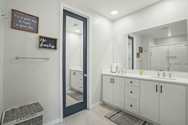 bathroom with tile patterned floors, a shower with shower door, and vanity