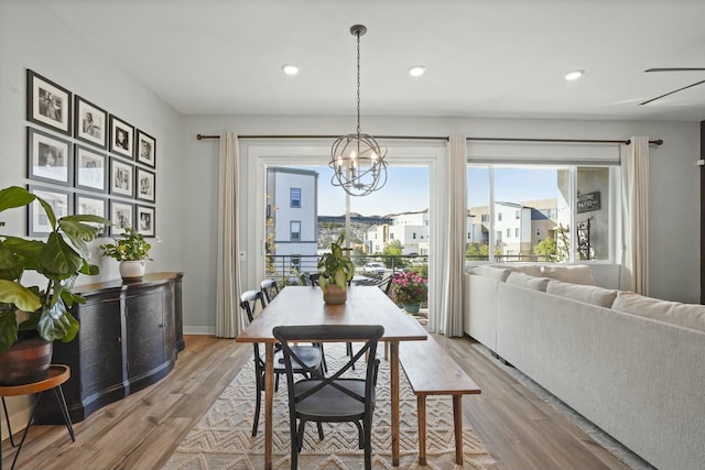 dining area featuring an inviting chandelier and light hardwood / wood-style flooring