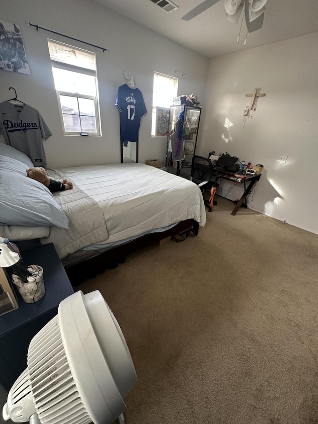 carpeted bedroom with multiple windows and ceiling fan