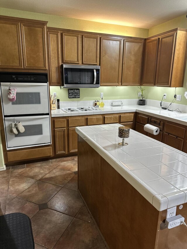 kitchen with tile counters and white appliances