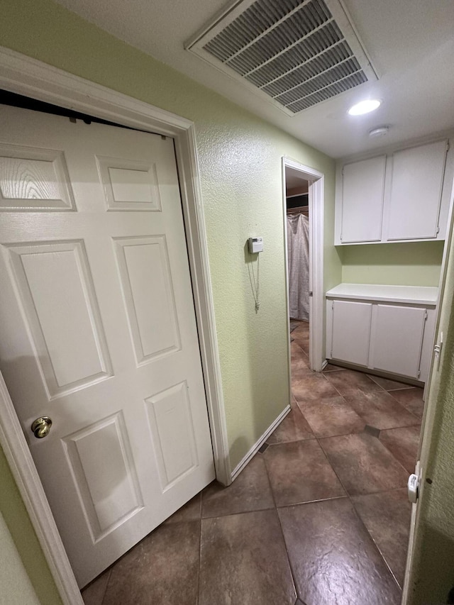 hallway featuring dark tile patterned floors