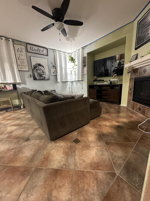 living room with ceiling fan and a tiled fireplace