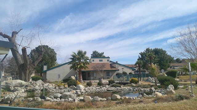 back of property featuring a garden pond