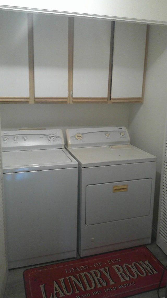 laundry room with cabinet space and washing machine and clothes dryer