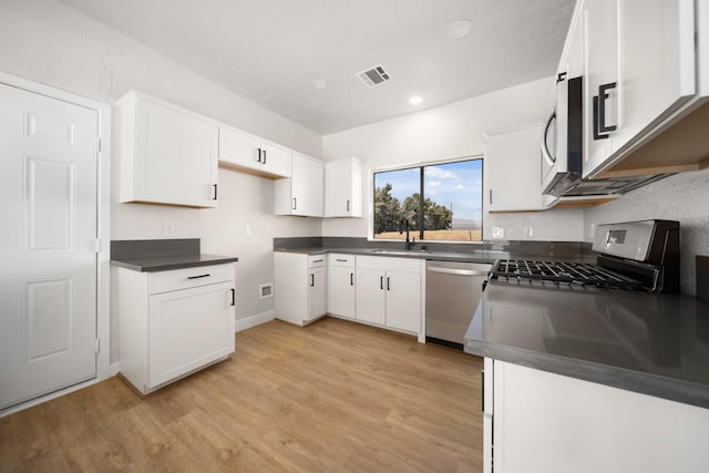 kitchen with white cabinetry, sink, stainless steel appliances, and light wood-type flooring