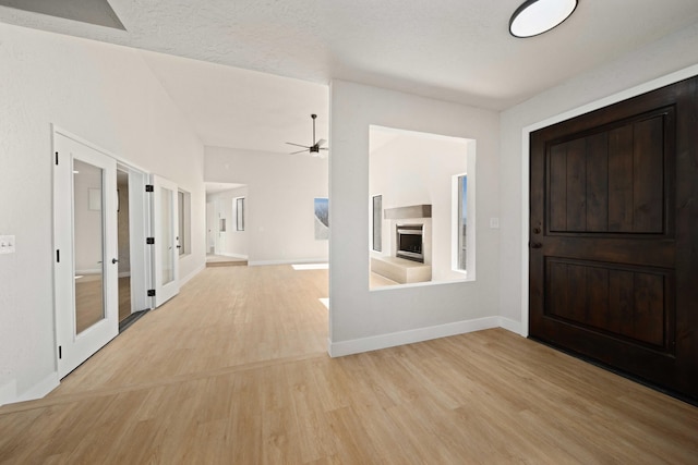 foyer with ceiling fan, french doors, a textured ceiling, and light wood-type flooring