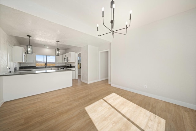 kitchen featuring a chandelier, decorative light fixtures, light hardwood / wood-style flooring, and white cabinetry