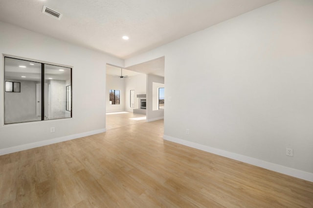 unfurnished room with ceiling fan and light wood-type flooring