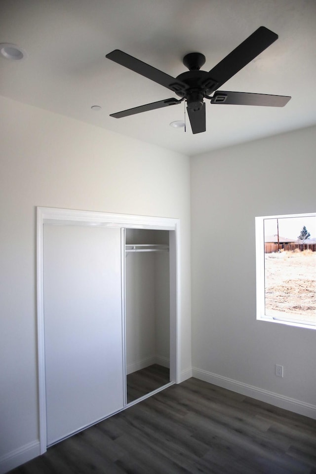 unfurnished bedroom with ceiling fan, a closet, baseboards, and wood finished floors