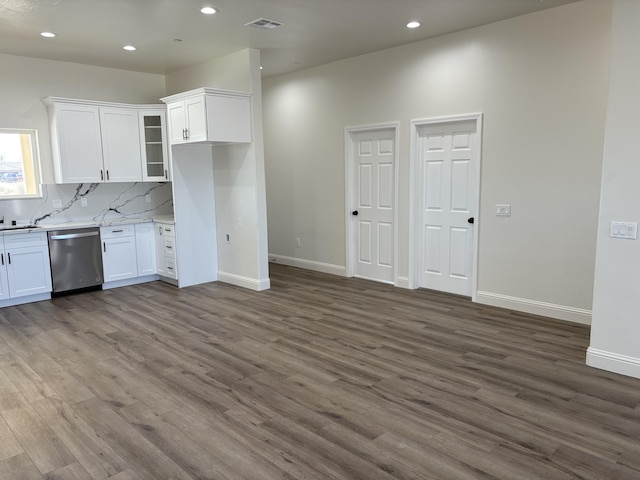 kitchen with backsplash, dark wood-style flooring, white cabinets, and stainless steel dishwasher