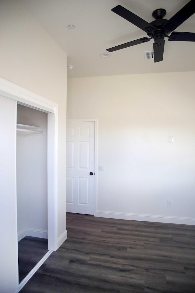 unfurnished bedroom with visible vents, dark wood-type flooring, a closet, baseboards, and ceiling fan