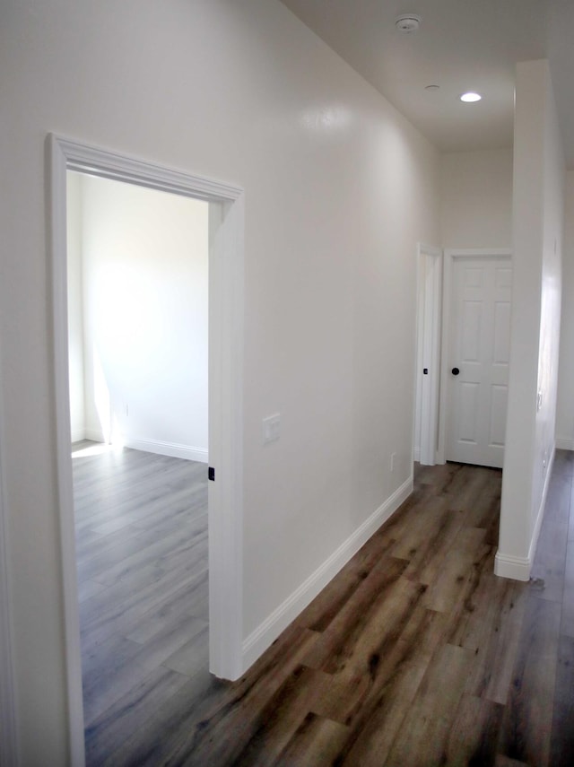 hall featuring recessed lighting, wood finished floors, and baseboards