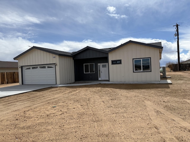 view of front facade featuring an attached garage, driveway, and fence