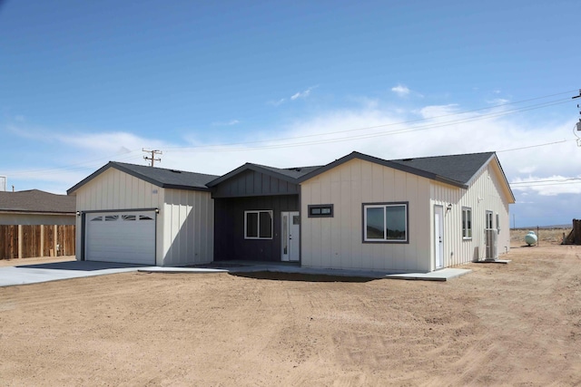 view of front of house featuring driveway, a garage, and fence