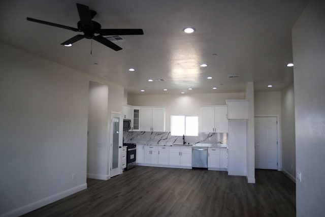 kitchen with a ceiling fan, a sink, white cabinetry, stainless steel appliances, and decorative backsplash