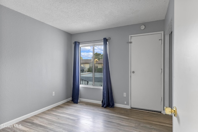 14332 Lear St, Mojave, CA 93501 - empty room with wood finished floors, a textured ceiling, and a smoke detector