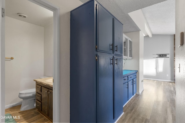 14332 Lear St, Mojave, CA 93501 - corridor with light wood finished floors, beam ceiling, and a textured ceiling