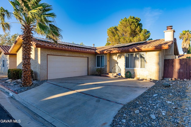 14332 Lear St, Mojave, CA 93501 - single story home with a tiled roof, an attached garage, and roof mounted solar panels