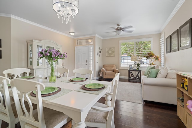 dining area featuring ornamental molding, ceiling fan with notable chandelier, and dark wood-type flooring