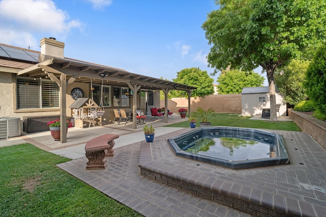 view of pool featuring central air condition unit, a patio area, a shed, a fenced backyard, and an in ground hot tub