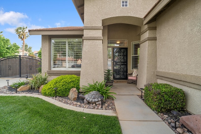 doorway to property with stucco siding and a gate