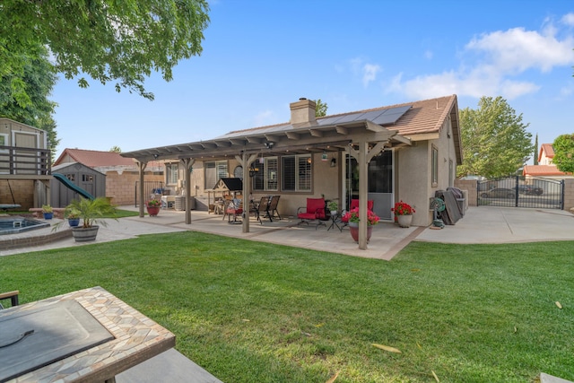 back of property with roof mounted solar panels, a gate, an outdoor structure, a fenced backyard, and a shed