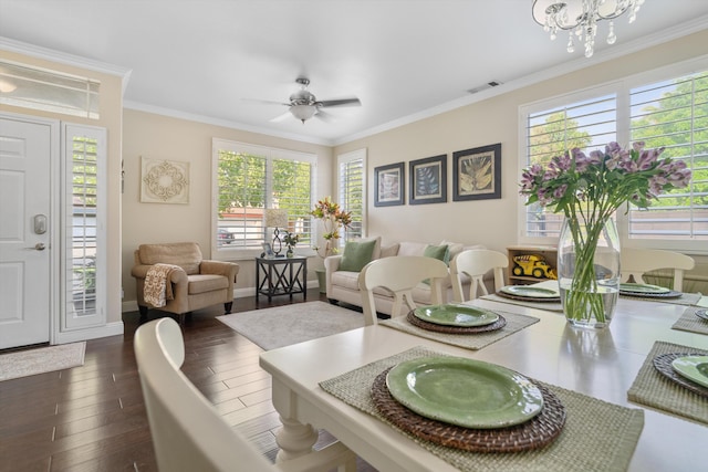 dining space with ceiling fan with notable chandelier, crown molding, and dark wood-type flooring