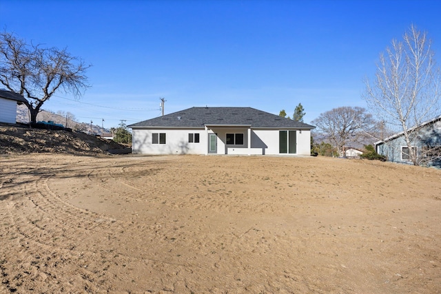 rear view of house with stucco siding