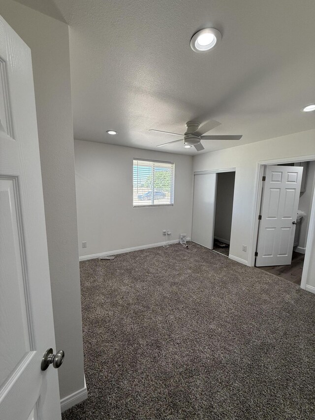 2202 E Lancaster Blvd, Lancaster, CA 93535 - unfurnished bedroom with dark carpet, baseboards, ceiling fan, a closet, and a textured ceiling