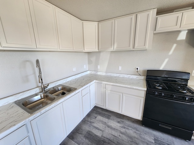 kitchen with sink, black gas stove, white cabinets, and dark hardwood / wood-style floors