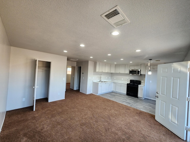 kitchen featuring black gas range oven, carpet floors, hanging light fixtures, a textured ceiling, and white cabinets