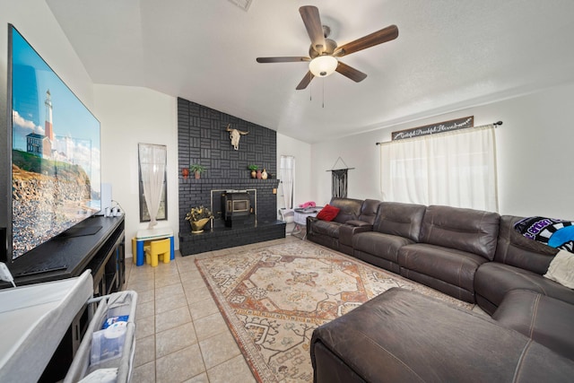 tiled living room with lofted ceiling, ceiling fan, and a wood stove